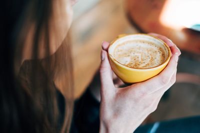 Close-up of hand holding coffee cup