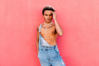 Portrait of gay man standing against wall outdoors