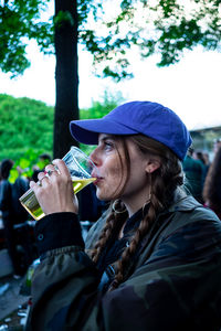 Portrait of woman drinking water from tree