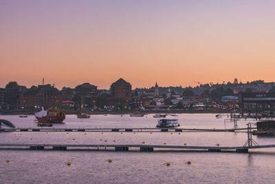 View of harbor and buildings against sky during sunset