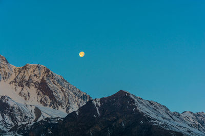 Scenic view of snowcapped mountains against clear blue sky