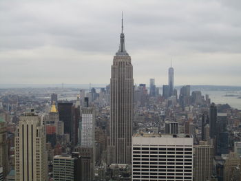 Buildings in city against cloudy sky