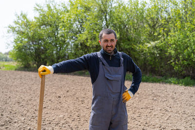 A man planting potatoes in the ground in early spring.