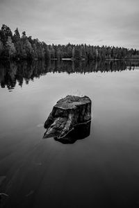 Scenic view of rock on lake against sky