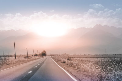 Road amidst landscape against sky during sunset