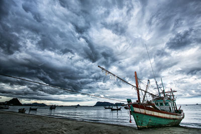 Sailboats moored on sea against sky