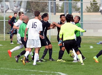 Men playing soccer on field