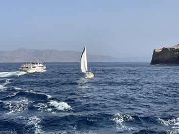 Sailboat sailing on sea against clear sky