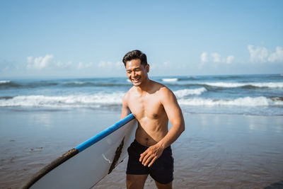 Portrait of shirtless man swimming in sea