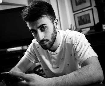 Portrait of young man sitting at home