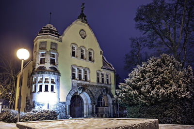 Low angle view of illuminated building against sky at night