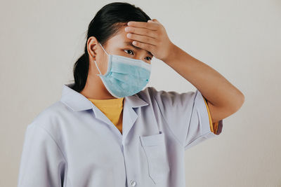 Portrait of a woman standing against white background