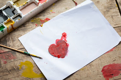 Painted heart shape on paper over messy table