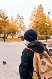 New normal. boy goes to school wearing protective mask during the coronavirus pandemic. back view.