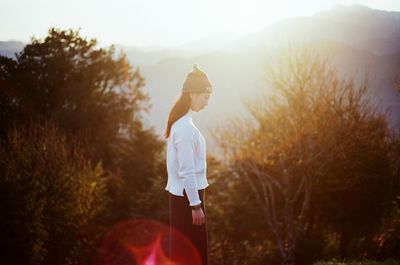 Full length of woman standing on tree trunk
