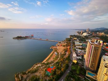 High angle view of city by sea against sky