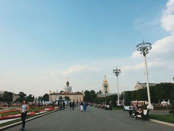 People on street in city against sky