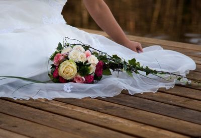 Low section of woman holding rose bouquet