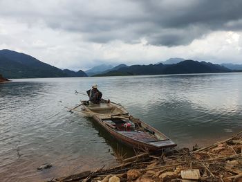 People on lake against sky