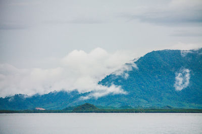 Scenic view of sea and mountains against sky