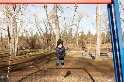 Full length of boy on swing during winter