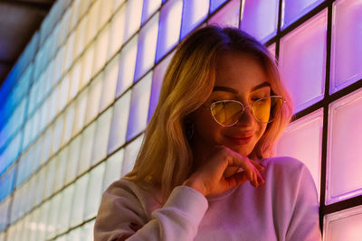 Portrait of beautiful woman against wall