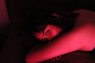 Close-up portrait of woman leaning in illuminated room