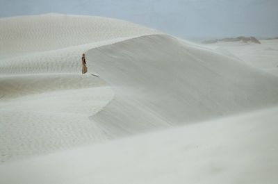 Distant view of woman standing at desert