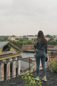 Rear view of woman standing on bridge against sky