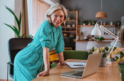 Portrait of young woman sitting on table