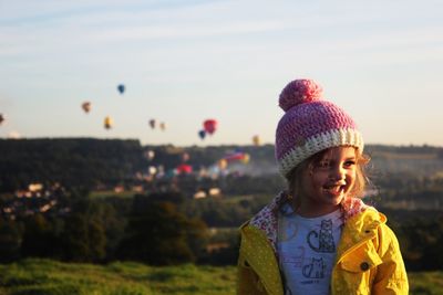 Close-up of smiling girl against sky