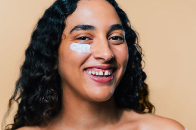 Close-up of young woman against pink background