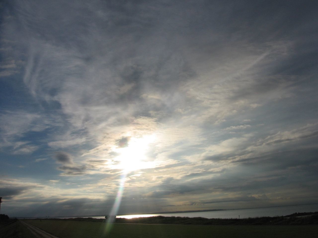 sky, cloud - sky, tranquility, tranquil scene, scenics, beauty in nature, sun, cloudy, nature, sunset, cloud, sunlight, sunbeam, landscape, idyllic, outdoors, no people, field, weather, silhouette