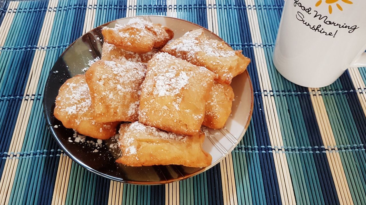 Beignets dusted with powdered sugar in natural linen napkin