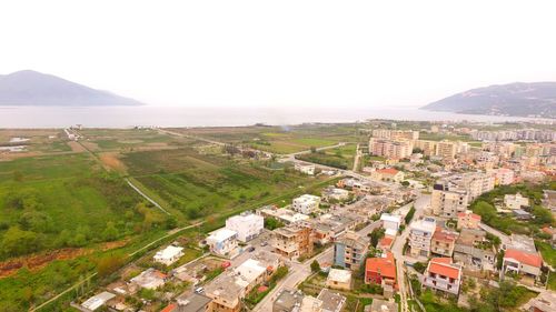 Aerial view of townscape by mountain against clear sky