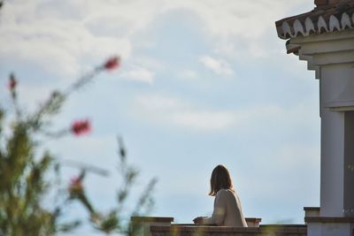 Side view of woman standing at balcony