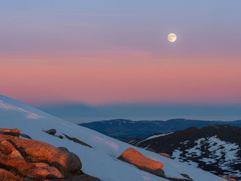 Scenic view of snowcapped mountains against sky during sunset