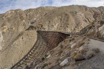 Tilt image of trestle on mountain against sky