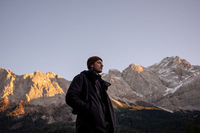 Man standing in mountains against clear sky