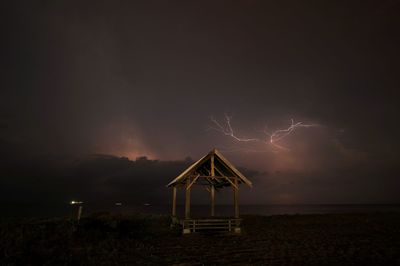 Lightning over sea against sky at night