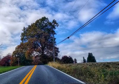 Road amidst trees against sky