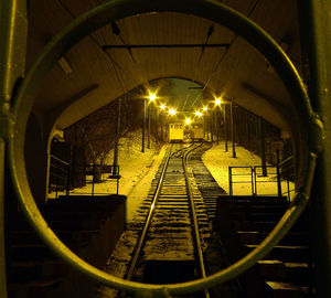 Railroad tracks in illuminated tunnel