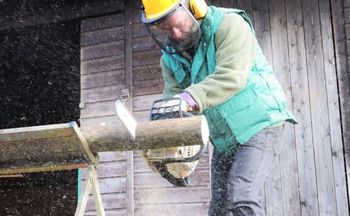Side view of man working on wood