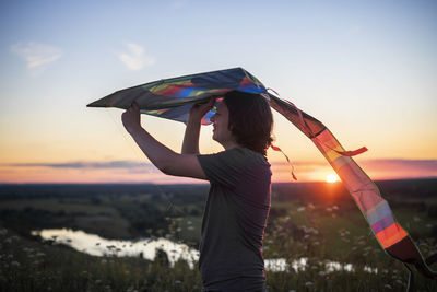 Rear view of woman holding umbrella