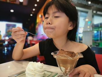 Girl enjoying ice cream in restaurant
