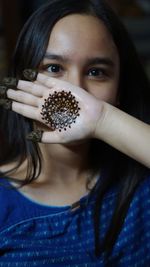 Portrait of young woman showing henna tattoo on her palm