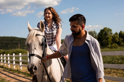 Young man with horse standing in the background