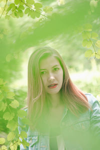 Portrait of young woman with green leaves