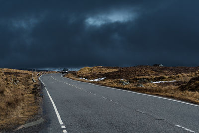 Empty road amidst landscape against sky