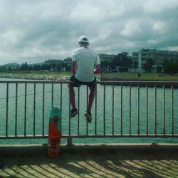 Rear view of woman standing by railing